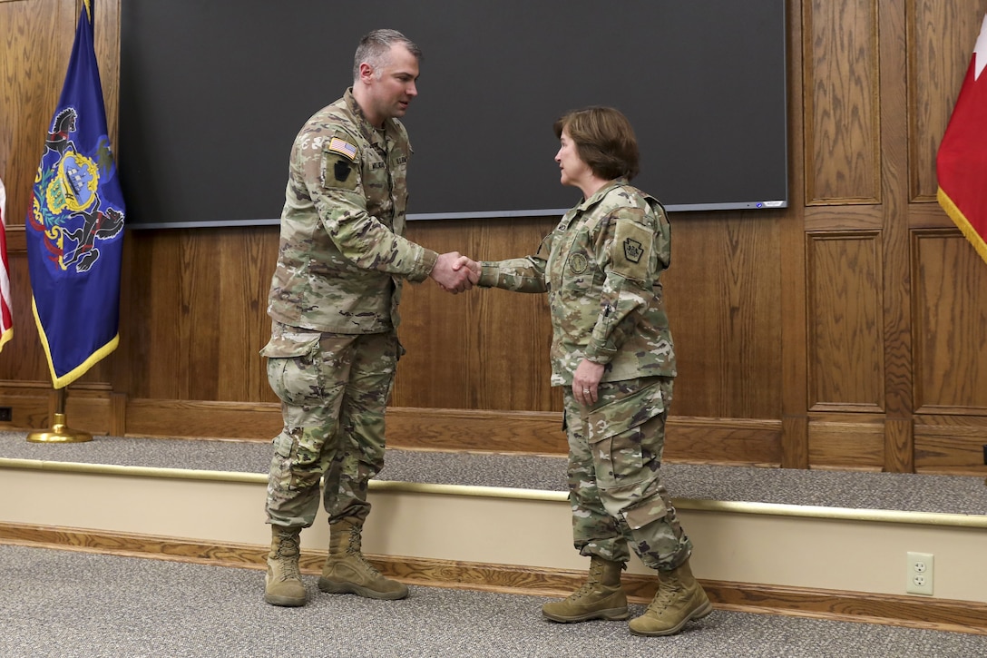 Maj. Gen. Laura McHugh, right, deputy adjutant general - Army, Pennsylvania National Guard, congratulates Sgt. 1st Class Denis Mulligan, Health Services and Support Branch Chief with the Pa. Guard’s G1 Services Division, for being recognized as the Army National Guard medical readiness noncommissioned officer of the year for large states April 2, 2025, at Fort Indiantown Gap, Pa. (U.S. Army National Guard photo by Sgt. 1st Class Zane Craig)