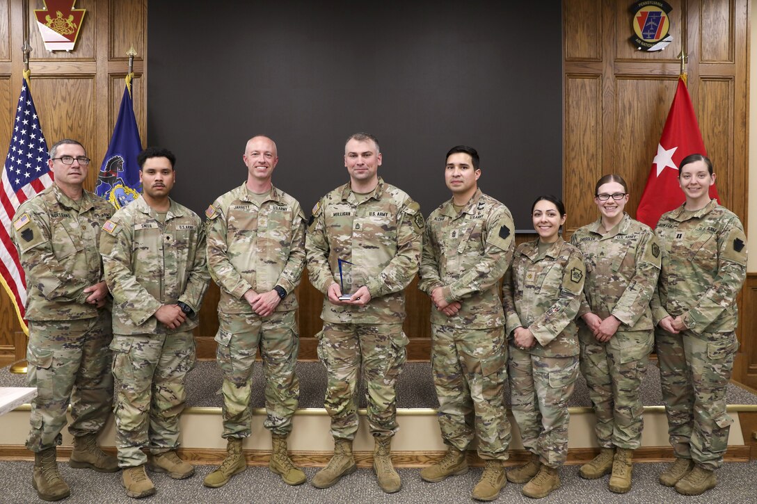 Sgt. 1st Class Denis Mulligan, fourth from left, Health Services and Support Branch Chief with the Pa. Guard’s G1 Services Division, was recently recognized as the Army National Guard medical readiness noncommissioned officer of the year for large states. The award is intended to recognize a medical readiness NCO who has demonstrated excellence in their position by contributing to high levels of medical readiness while serving. (U.S. Army National Guard photo by Sgt. 1st Class Zane Craig)
