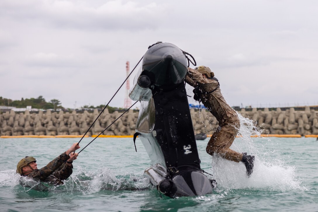 U.S. Marines practice flipping over combat rubber raiding crafts during small boat handling training on Camp Schwab, Okinawa, Japan, January 23, 2025. The training familiarized Marines with basic CRRC operations, handling, maneuvering, and emergency procedures. The Marines are with 3d Reconnaissance Battalion and 3d Marine Division. (U.S. Marine Corps photo by Sgt. Noah Masog)