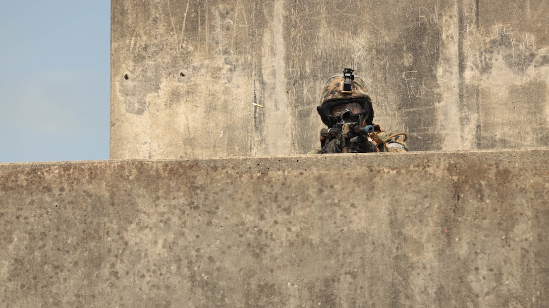 A U.S. Marine with Headquarters Battalion, 3d Marine Division engages with enemy combatants during Exercise Samurai 23.2 in the Central Training Area on Okinawa, Japan, April 27, 2023. Samurai 23.2 demonstrated HQBN’s ability to serve as a security force for the division in an urban environment and developed proficiency in combat tactics. (U.S. Marine Corps photo by Lance Cpl. Evelyn Doherty)