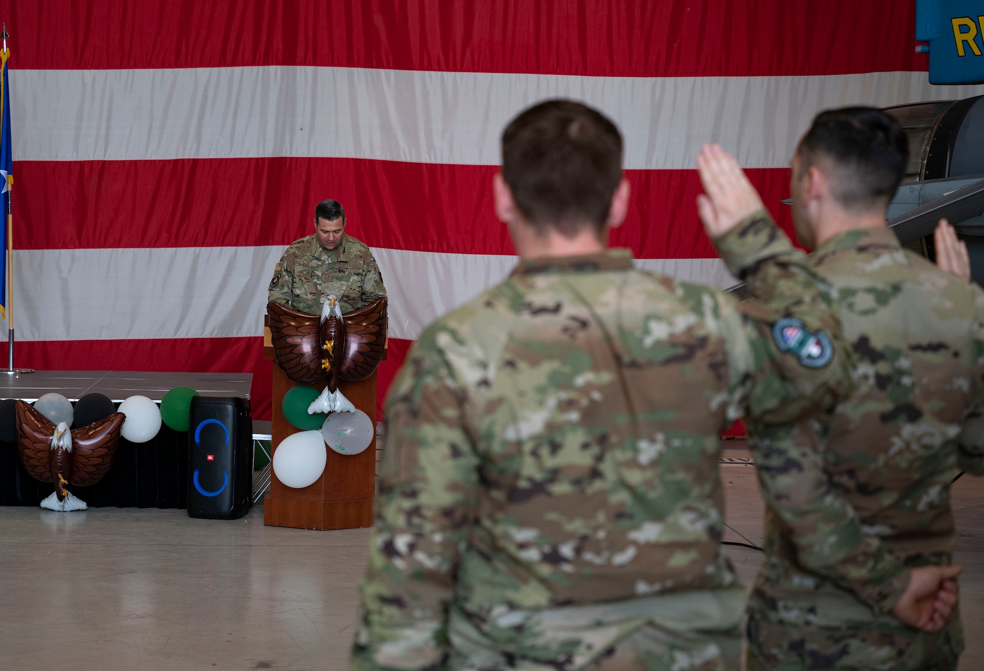 Service members hold up right hand for an oath