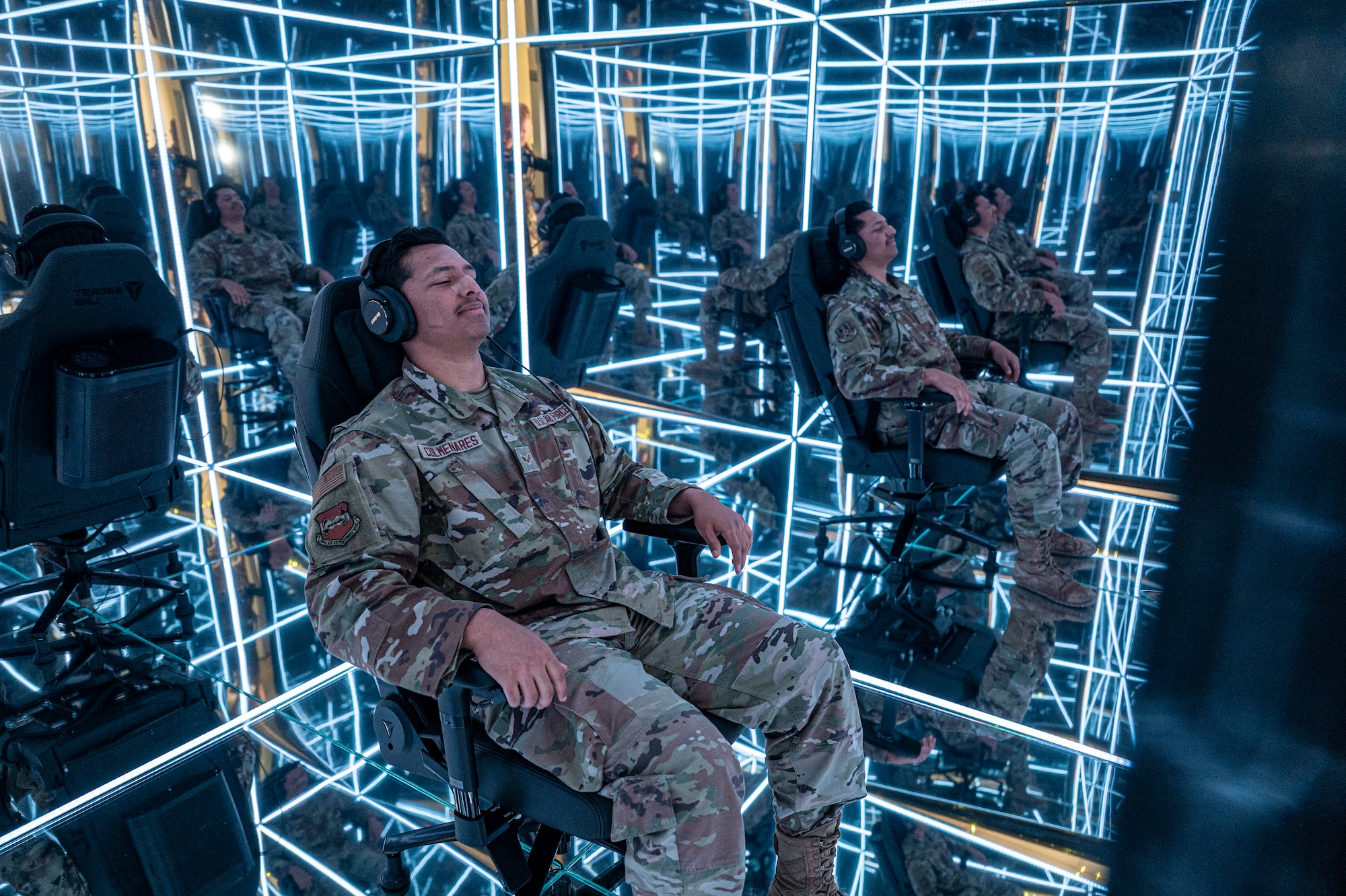Senior Airman Mark Colmenares sits in a chair centered in the MindGym's reflective cube with a pair of headphones in as he's immersed into the sensory deprivation therapy provided by the MindGym