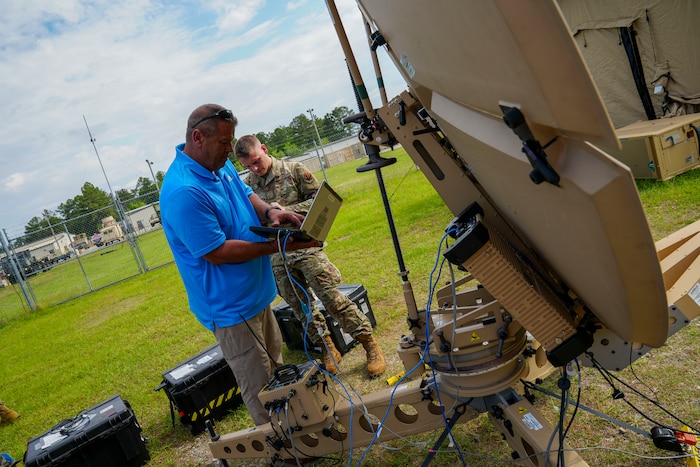 An Airman from 51st CBCS and AFETS representative dial in a satellite frequency on a satellite communications terminal to lock onto the WTS One Satellite during the 2025 XCOMM Roundup at Robins Air Force Base, Georgia, April 28, 2025.