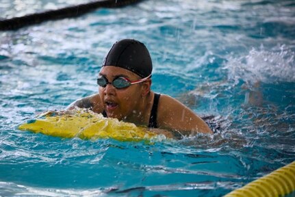 U.S. Army Capt. Channda Mitchell practices swim techniques, with a paddle board during swim practice at the 2025 Army Trials.