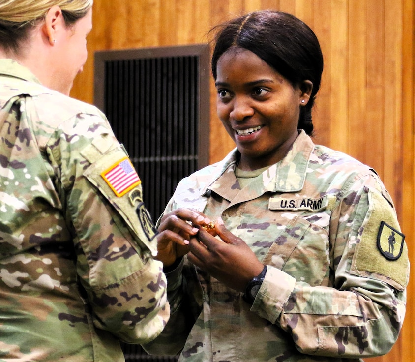 Juliana Nkafu accepts the cyber branch crest from Lt. Col. Jaime Marlock, the Illinois Army National Guard’s information technology and cyber branch chief.