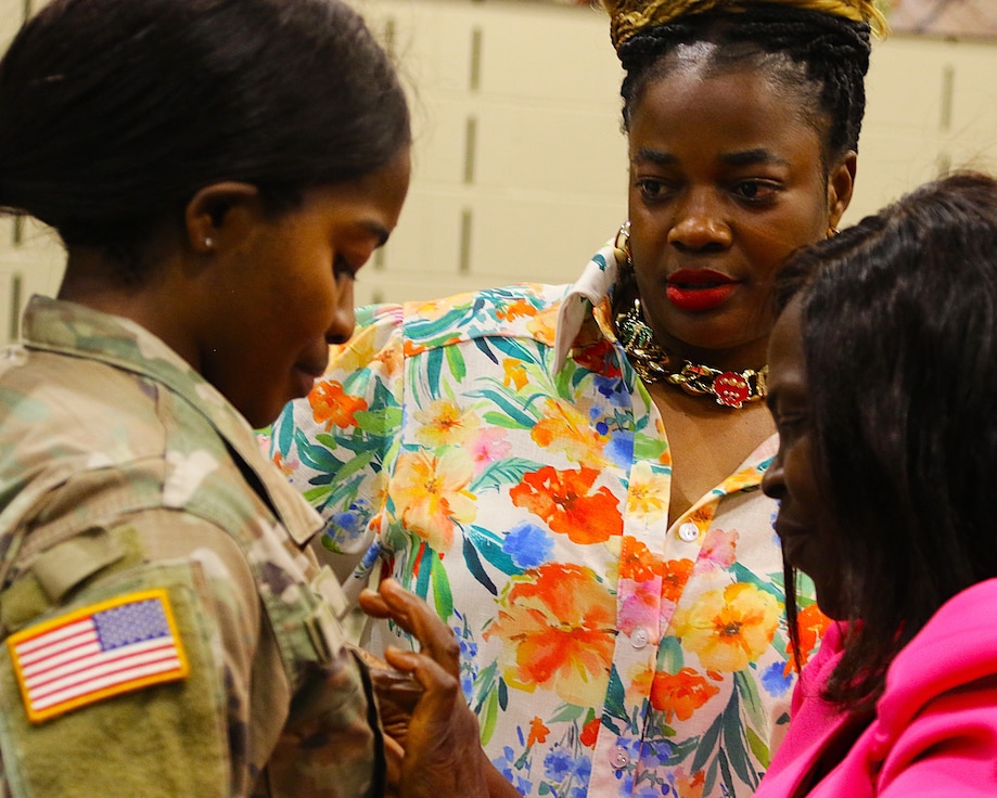 Anastasia Asong pins second lieutenant rank on her niece, Juliana Nkafu, as Euchinie Amindeh looks on.