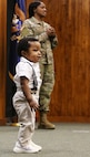 2nd Lt. Juliana Nkafu speaks to a group of officer candidates as her nephew, 13-month-old James Akemanji Nkengayi, also takes the stage at her commissioning ceremony.