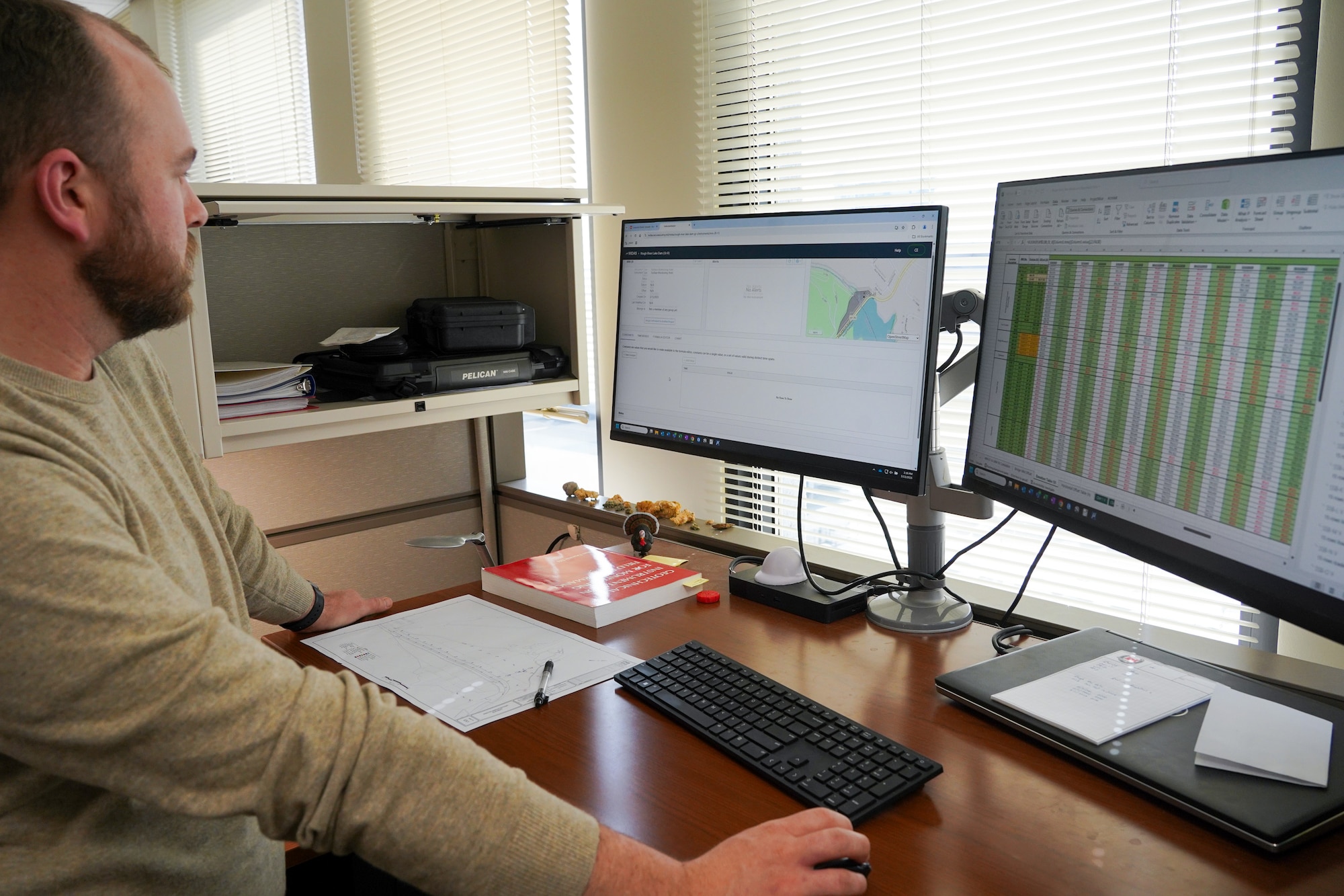 Connor Estes, a geologist with the Dam Safety Section, reviews data from the MIDAS system installed at Rough River Dam in Falls of Rough, Kentucky from his workstation in the Louisville District March 13, 2025.