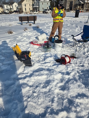 A contractor takes a groundwater sample from a monitoring well in January 2025 prior to initiation of the treatability study.