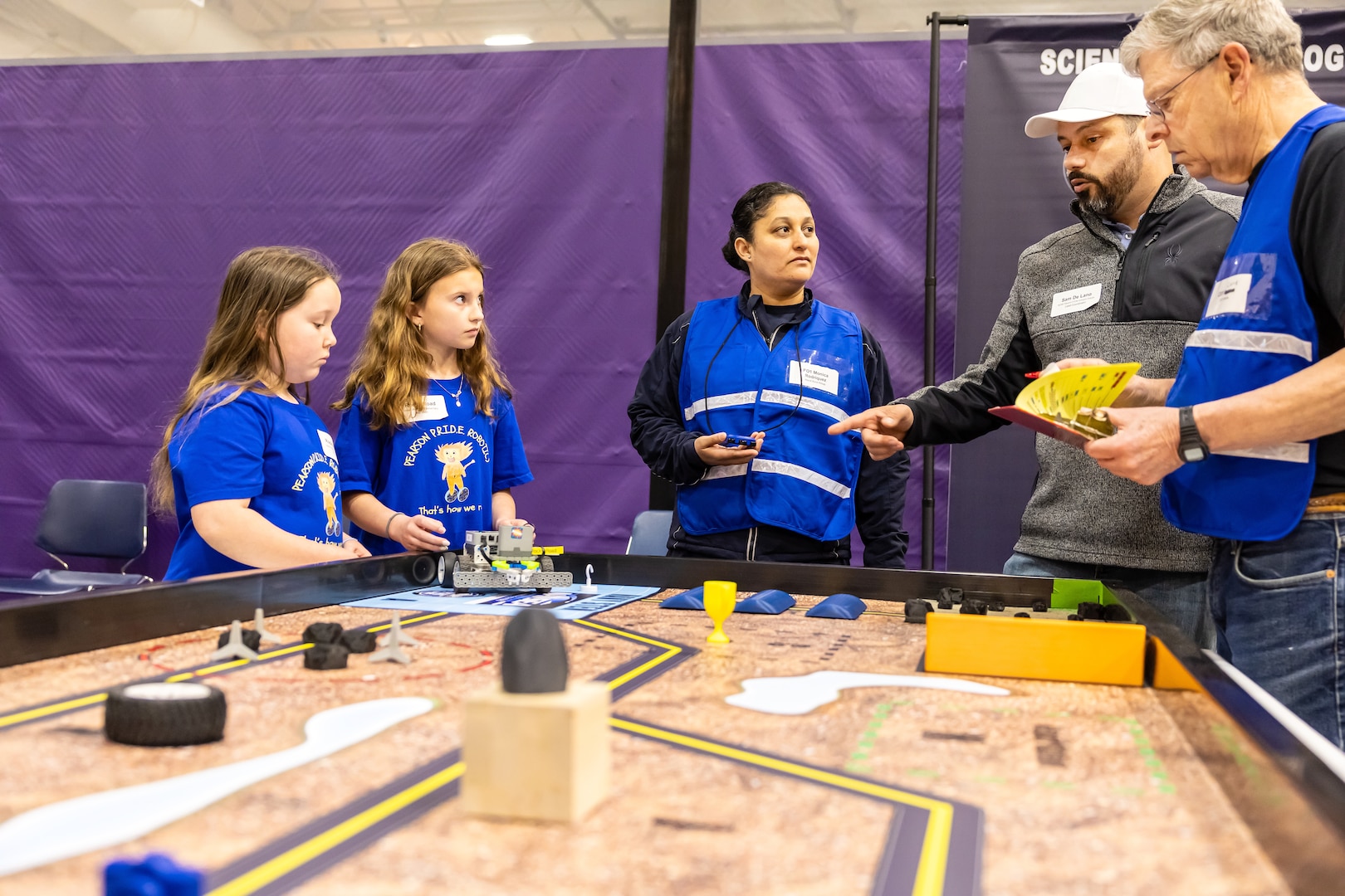 Volunteers provide instructions to a team of elementary students from Cottonwood Elementary School April 29, 2025, during the 3rd Annual Navy Peninsula Robotics Competition at North Kitsap High School in Poulsbo, Washington. (U.S. Navy photo by Jeb Fach)