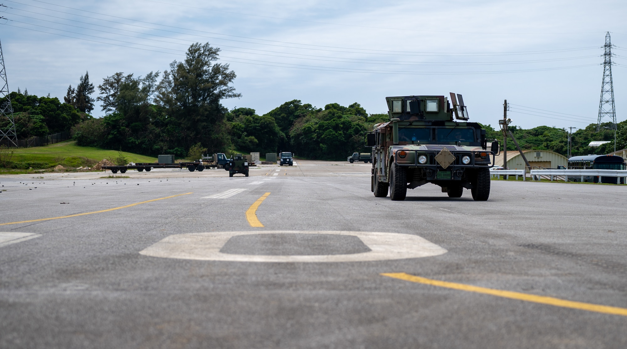 Military members drive on a simulated flightline in a vehicle