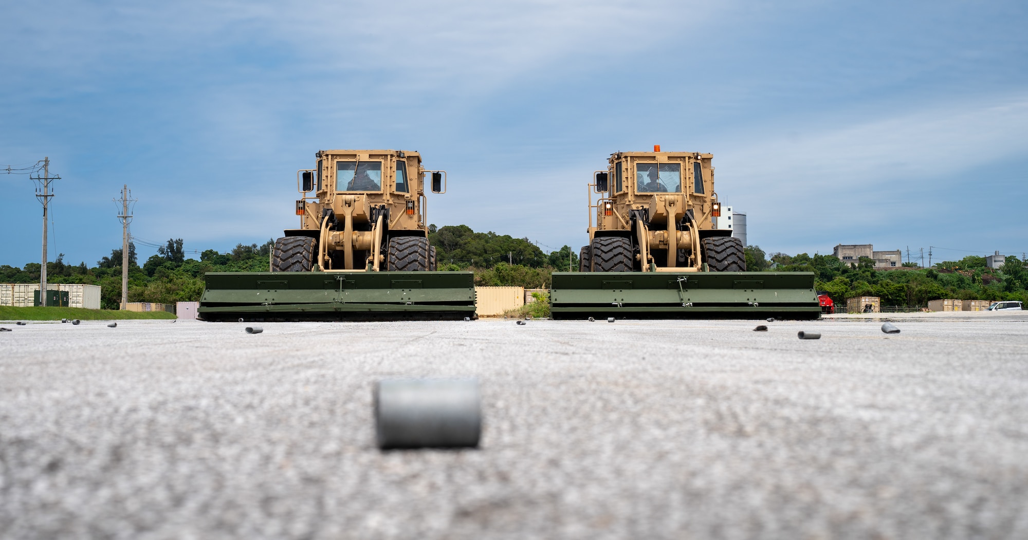 Two front loaders sit on a flightline next to eachother