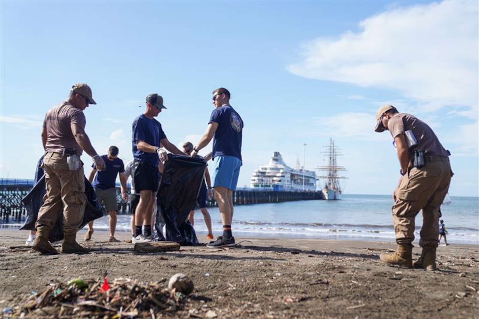Crewmembers from U.S. Coast Guard Barque Eagle work with members of the Costa Rican Coast Guard to clean up local beaches in Puntarenas, Costa Rica on April 27, 2025. Eagle crew also participated in numerous media engagements and conducted ship tours with its counterparts from the Costa Rican Coast Guard, further strengthening relationships with our international partners. (U.S. Coast Guard courtesy photo by U.S. Embassy Costa Rica.)