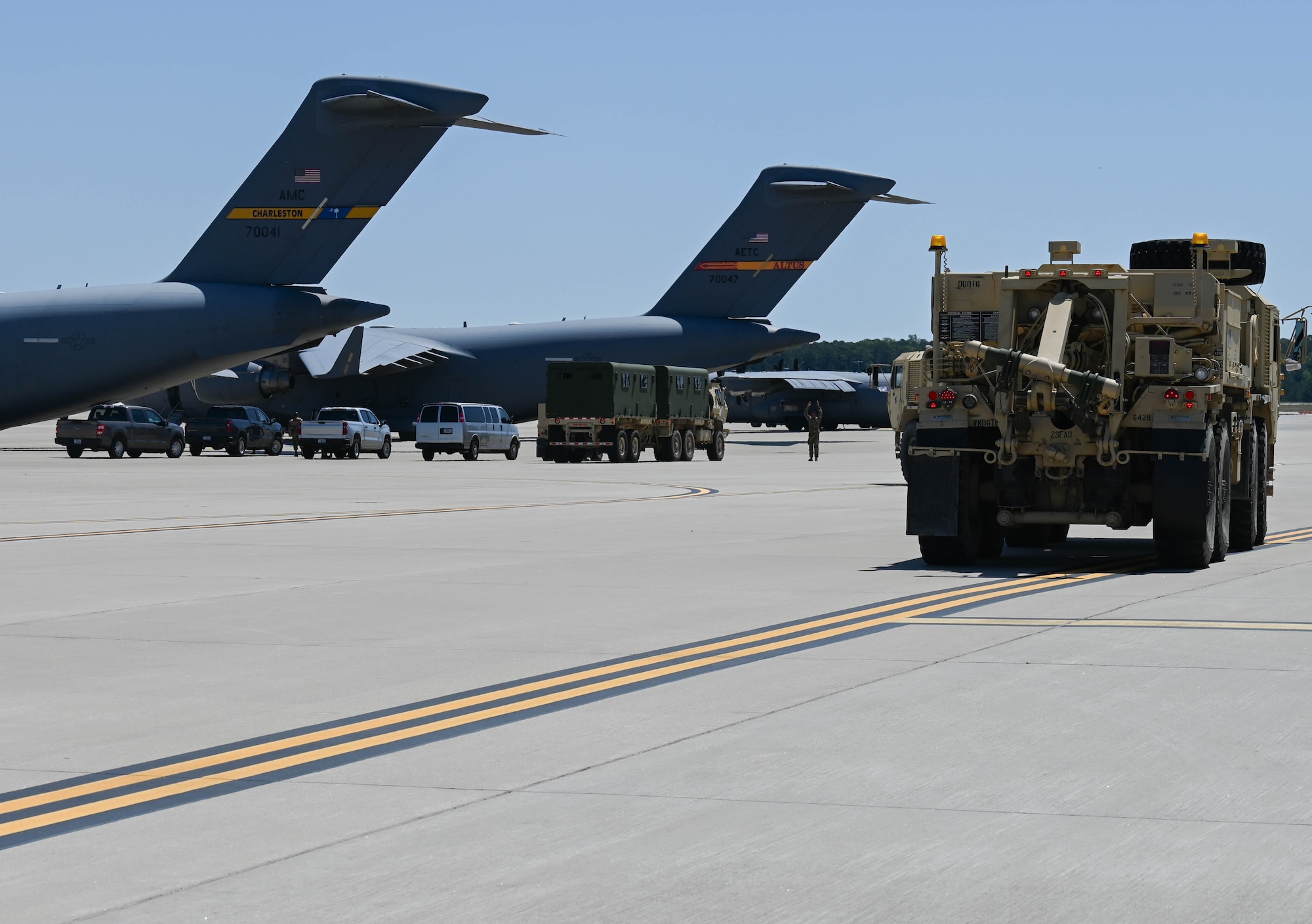 An Army tactical vehicle drive up to an aircraft.
