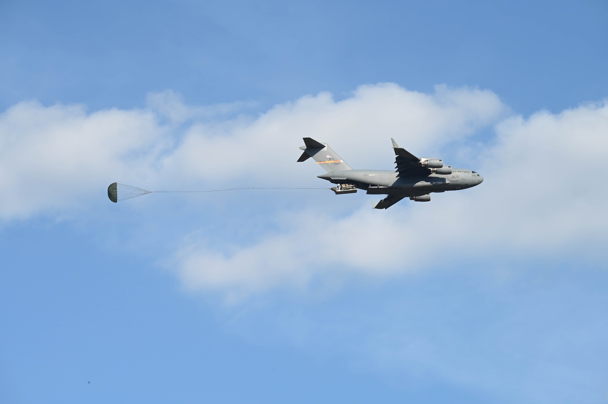 An Aircraft drops cargo in air.