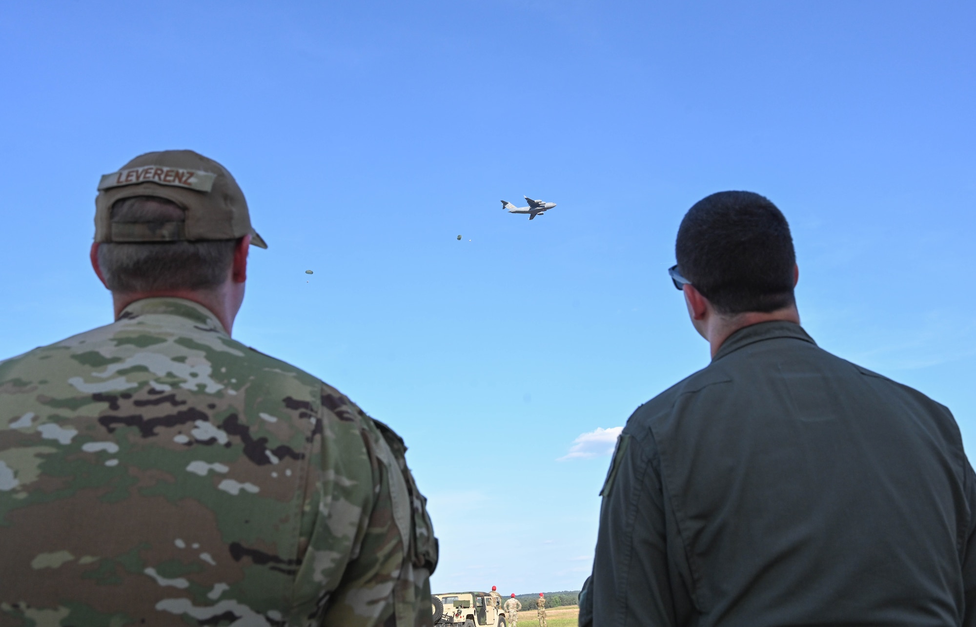 Two Airman watch cargo drop.