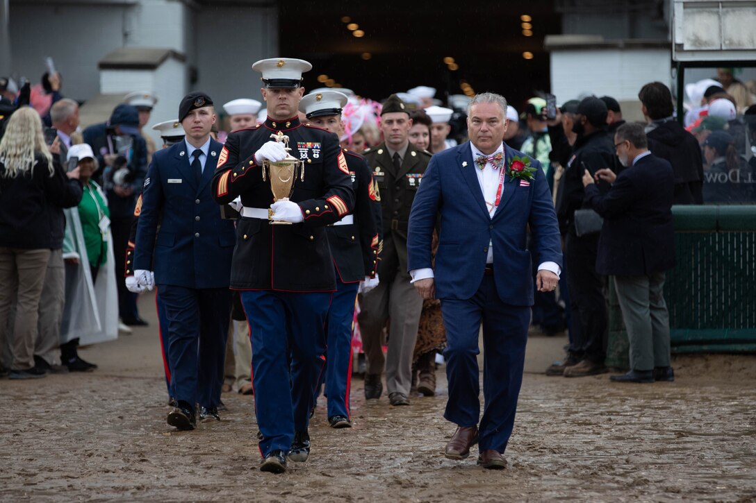 Service members assigned to the Kentucky Derby Trophy Guard escort the trophy across the track during the 151st running of the Kentucky Derby at Churchill Downs in Louisville, Kentucky, May 3, 2025. Each Derby trophy is hand crafted months in advance, and during race day, it is not to be handled by anyone other than authorized service members until presentation to the victor. (U.S. Army National Guard photo by Sgt. Caleb Sooter)