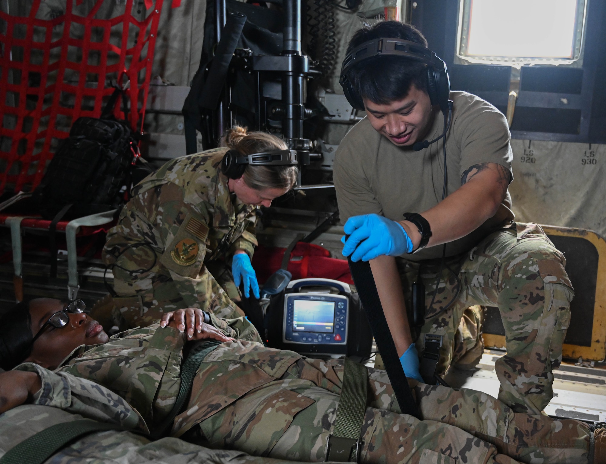 An Airman secures a volunteer patient for flight.