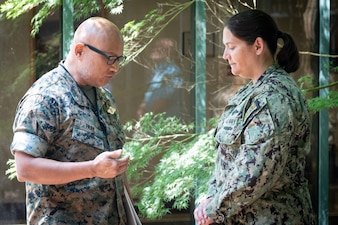 Commander Stacey Swindells, right, a Nurse serving aboard Naval Health Clinic Cherry Point, prays with Navy Chaplain Commander Philip Park during a Blessing of the Hands ceremony Wednesday, May 7. The spiritual fitness event honored the compassion and professionalism of the nursing staff serving in the facility while fortifying their spiritual resolve.