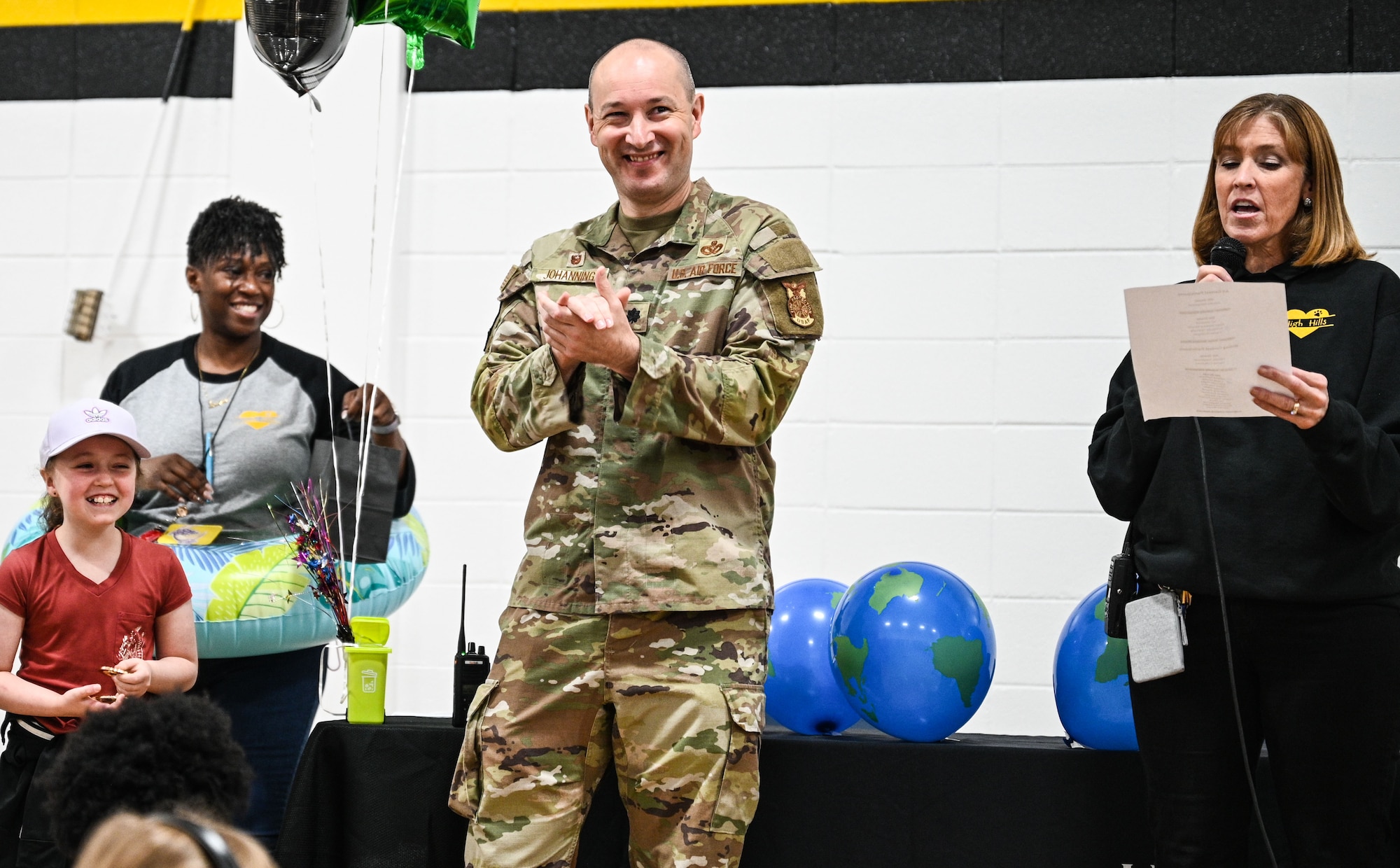 Lt. Col. Johanning and staff and student from the school stand in front of the student body to present awards.
