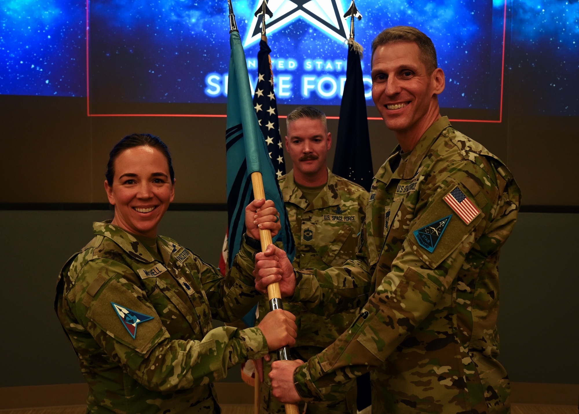 U.S. Space Force Chief Master Sgt. Paul Norris, right, passes the Space Delta 1 guidon to U.S. Space Force Lt. Col. Stephanie Mitchell, Space Delta 1 director of staff, during the unit’s change of responsibility ceremony.