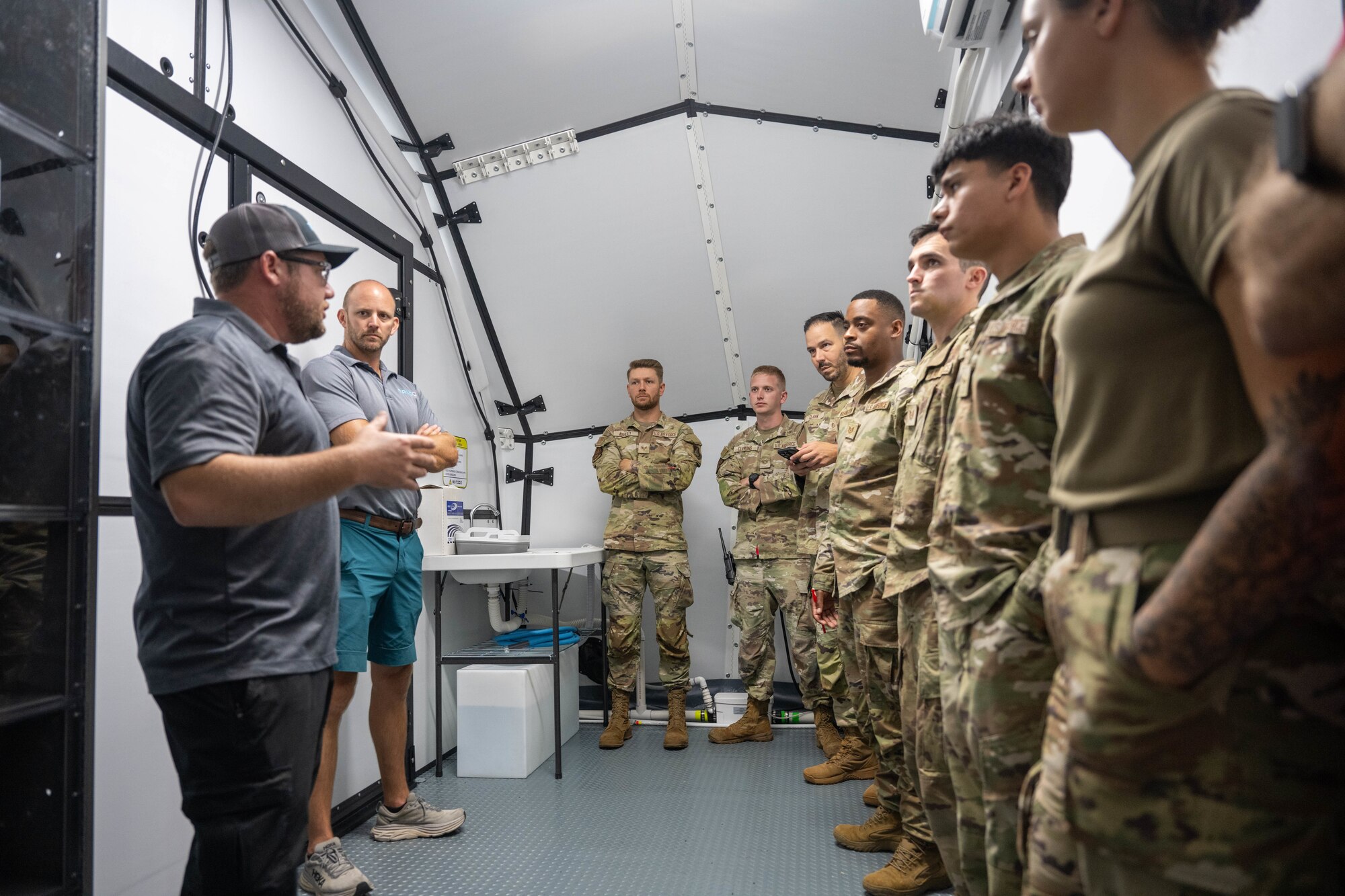 Airmen receiving a brief from a contractor.