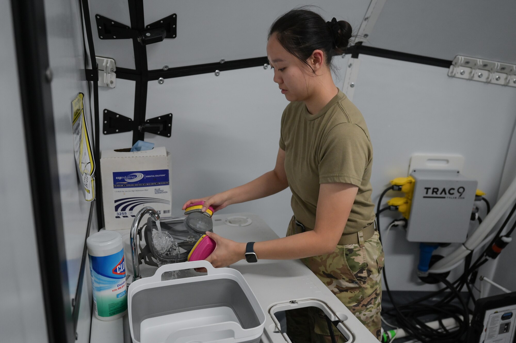 Airman washing protective face mask.