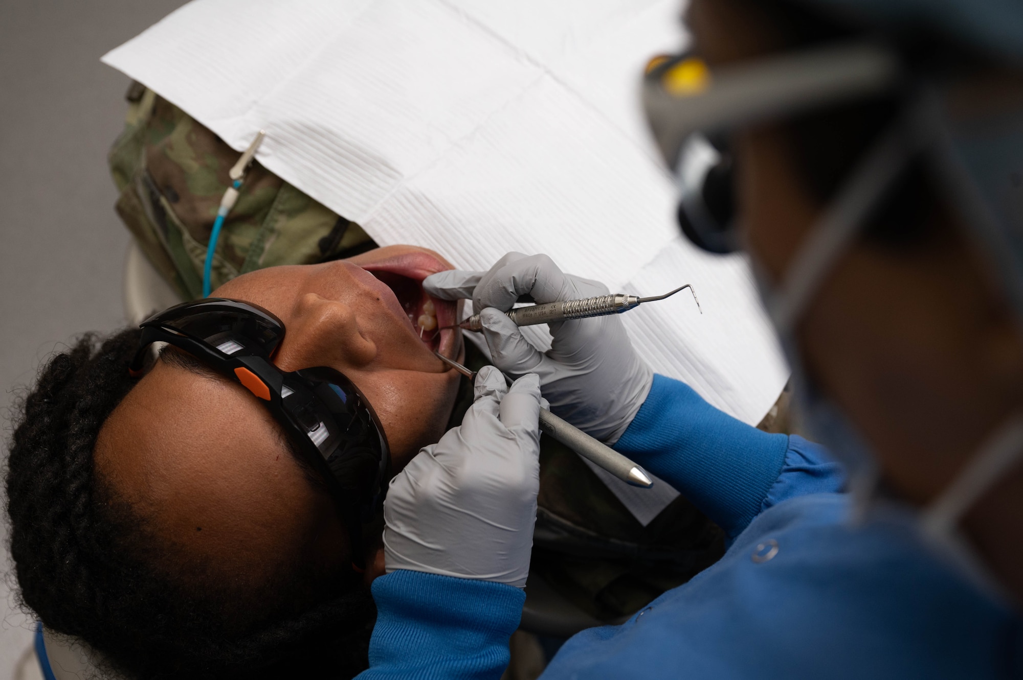 U.S. Air Force 2nd Lt. Sarah Ellis, student doctor at Midwestern University, examines her patient's teeth, May 2, 2025, at Luke Air Force Base, Arizona.