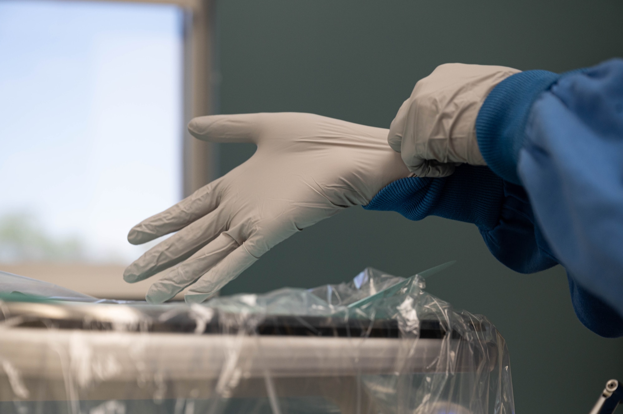 U.S. Air Force 2nd Lt. Sarah Ellis, student doctor at Midwestern University, puts on gloves while preparing to see her patient, May 2, 2025, at Luke Air Force Base, Arizona.