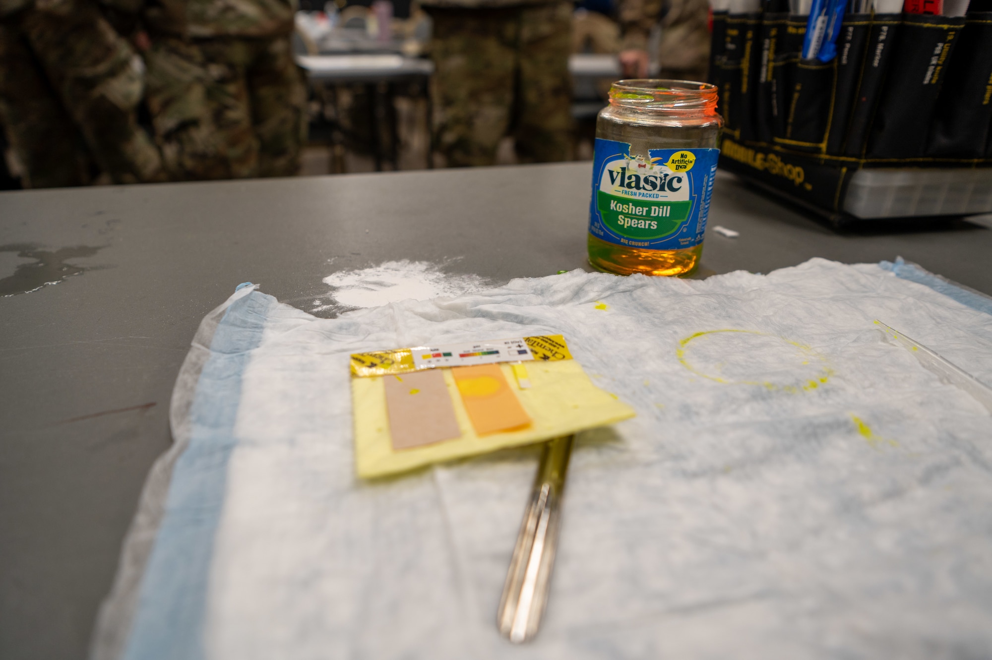 Fake hazardous material is used during classroom instruction to demonstrate using detection strips during a hands-on CBRN response exercise at Goldwater Air National Guard Base, Ariz, Jan. 31, 2025. This training enhances rapid decision-making and operational readiness in emergency situations. (U.S. Air Force photo by Staff Sgt. Alexis Orozco)