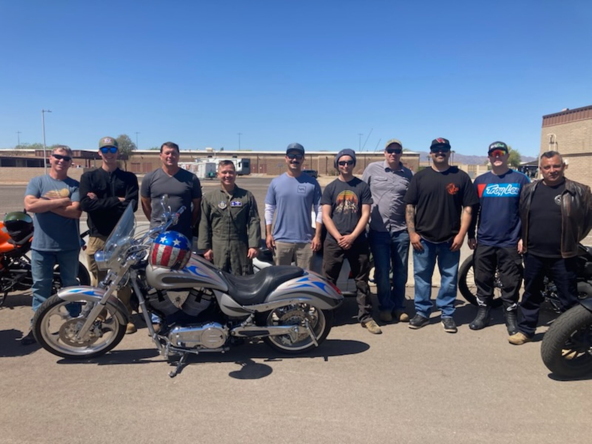 Participants of the 944th  Fighter Wing Annual Spring Mentorship Ride pose for a photo with this years' lead, Col Todd Riddle 944th FW commander, at Luke Air Force Base, Ariz., April 2025. The Motorcycle Safety Representatives, assist members with a preseason Tires, Controls, Lights, Oil, Chassis, and Stands, inspection, helping to ensure rider safety and meet their Level lll class requirements.(U.S. Air Force Courtesy Photo)
