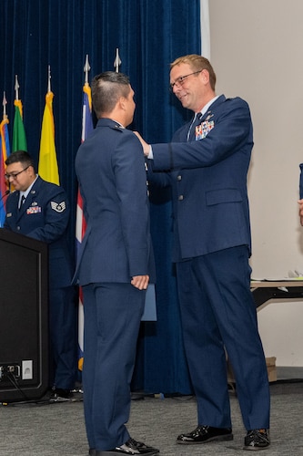 Col. Bryan Tuinman, Inter-American Air Forces Academy commandant, pins a USAF student during a graduation ceremony from the Inter-American Air Forces Academy at Joint Base San Antonio -Lackland, Texas, April 17, 2025.