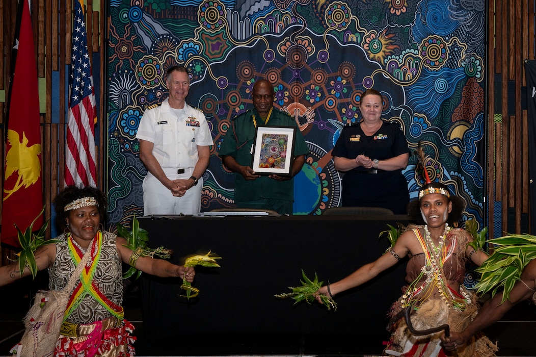 U.S. Navy Capt. Peter Roberts, U.S. Indo-Pacific Command Command Surgeon, and Royal Australian Air Force Air Commodore Nicole dos Santos, RAAF Director General Operational Health and Air Force Health Service, gives Papua New Guinea Defence Force Lt. Col Peter Kaminiel, PNGDF Director General, a gift at the Indo-Pacific health security alliance in Port Moresby, Papua New Guinea, May 8, 2025. IPhsa aims to foster partnerships, counter harmful influences and enhance readiness, contributing to stability, prosperity and a free and open Indo-Pacific. (U.S. Army Photo by Sgt. Austin Riel)