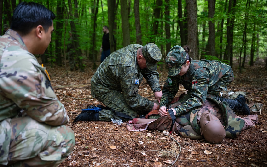 Participants of a four-day multilateral medical event provide care to a mannequin under simulated fire at Landstuhl, Germany, April 25, 2025. The event brought together military medical professionals from Kosovo, Armenia, Albania and Moldova, to exchange ideas and improve their understanding of medical simulation training, equipment and practices. (U.S. Air Force photo by Senior Airman Jared Lovett)