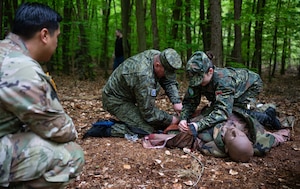 Participants of a four-day multilateral medical event provide care to a mannequin under simulated fire at Landstuhl, Germany, April 25, 2025. The event brought together military medical professionals from Kosovo, Armenia, Albania and Moldova, to exchange ideas and improve their understanding of medical simulation training, equipment and practices. (U.S. Air Force photo by Senior Airman Jared Lovett)