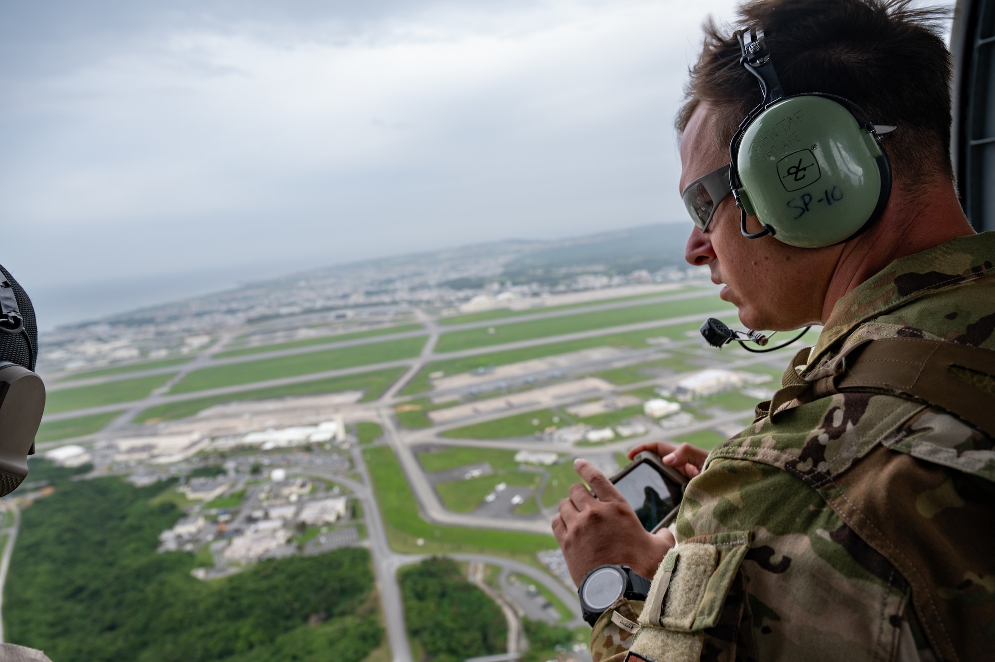 An EOD Airman scanning the airfield from a helicopter