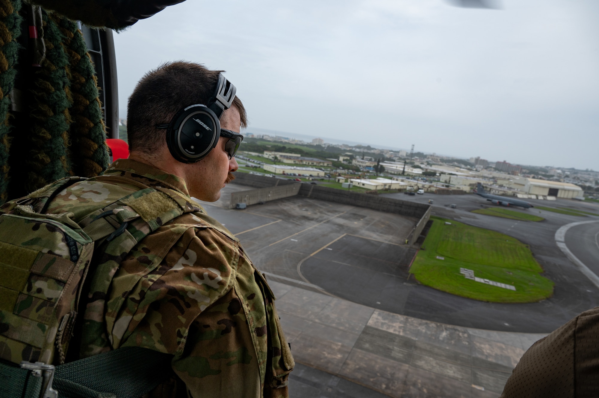 An EOD Airman scanning the airfield from a helicopter