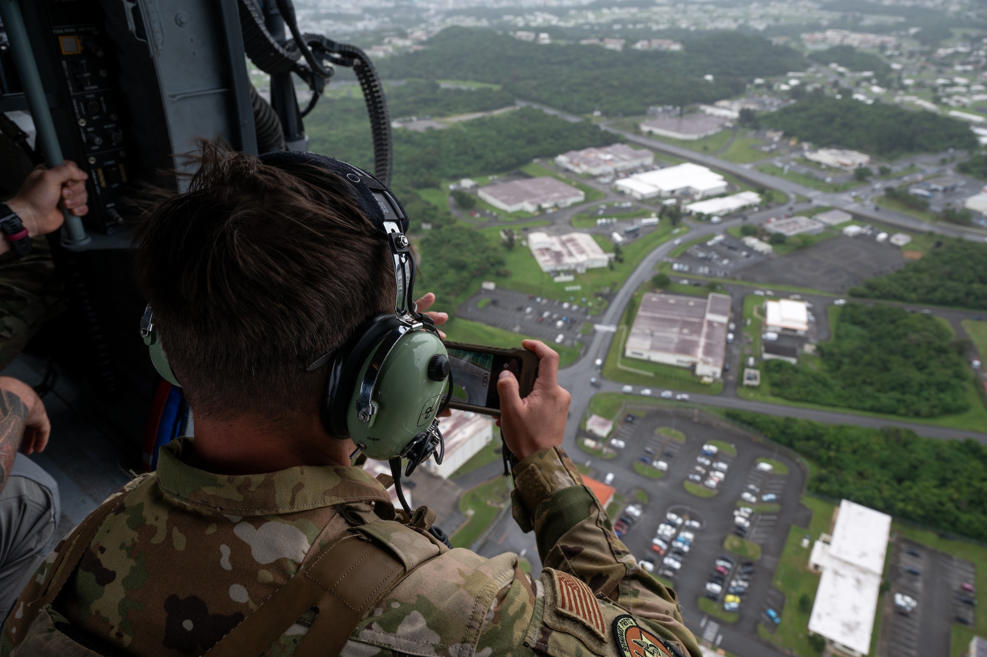 An EOD Airman scanning the airfield from a helicopter
