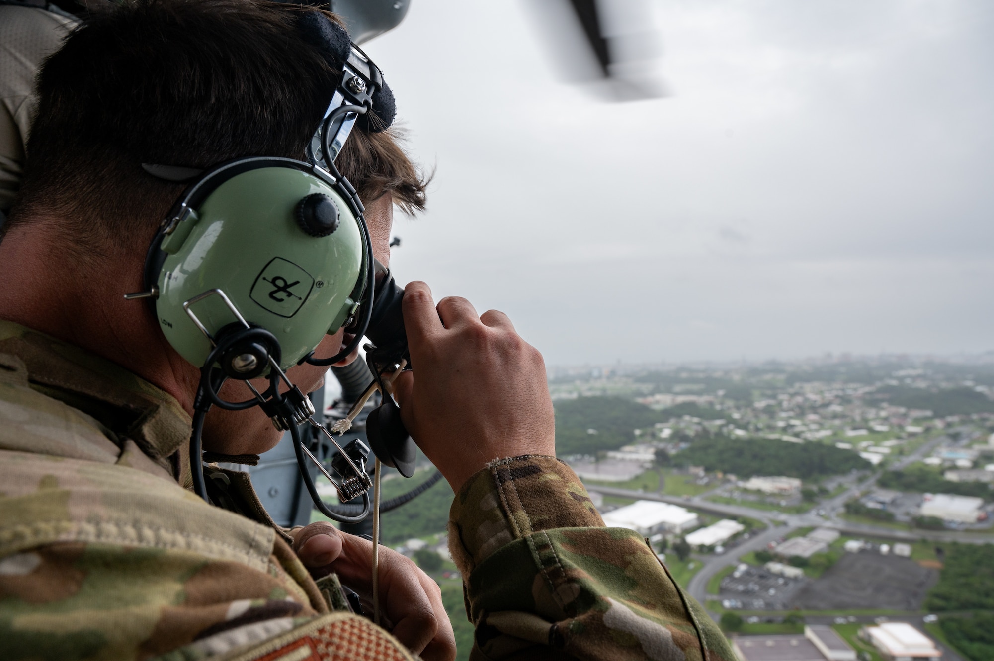 An EOD Airman scanning the airfield from a helicopter.