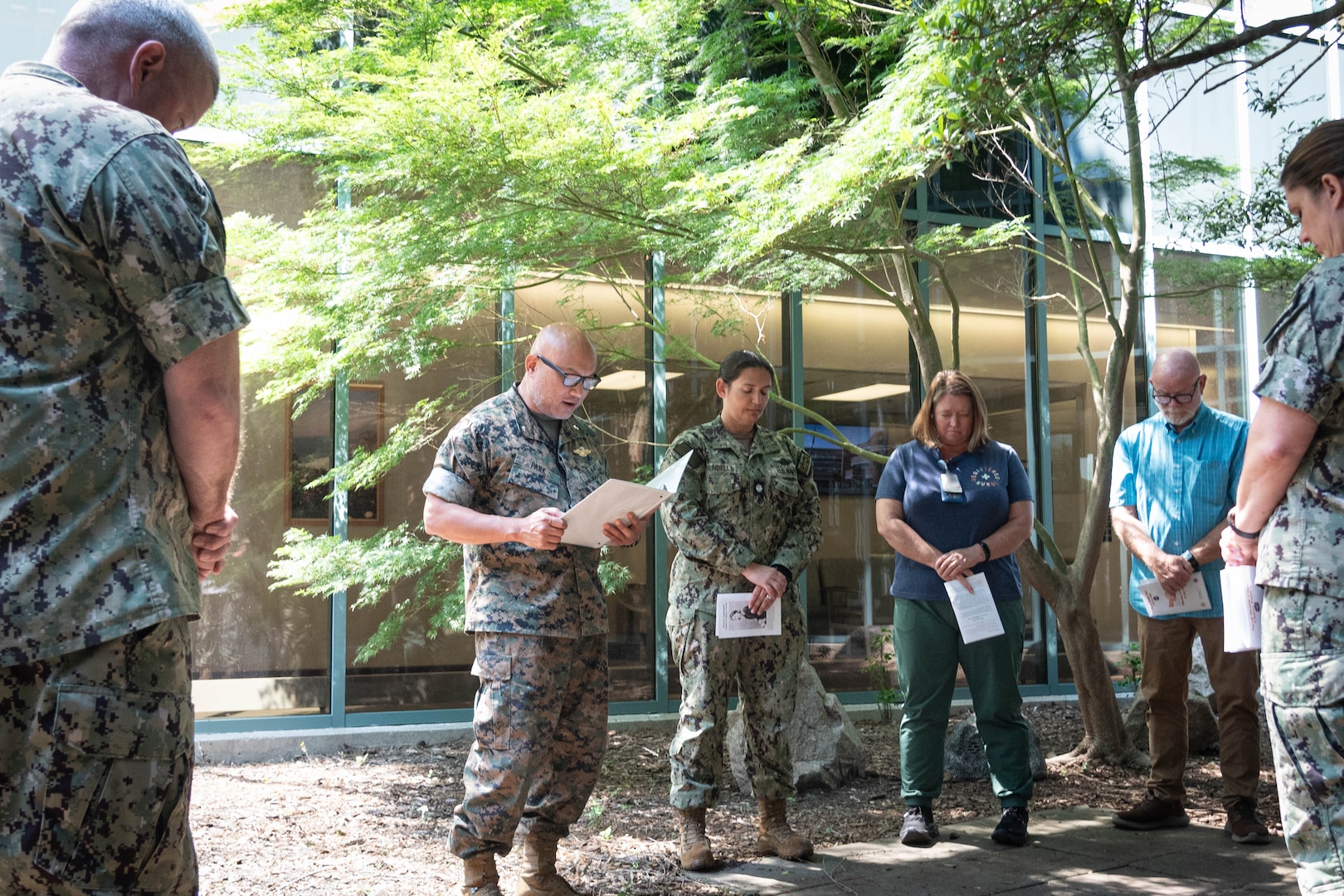 Navy Chaplain Commander Philip Park, second from left, reads a scripture passage during a Blessing of the Hands ceremony held at Naval Health Clinic Cherry Point on Wednesday, May 7.  The spiritual fitness event honored the compassion and professionalism of the nursing staff serving in the facility while fortifying their spiritual resolve.