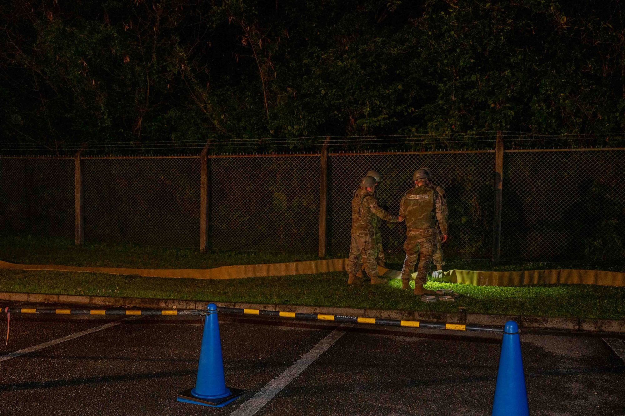 Service members assess the connection of a hose.