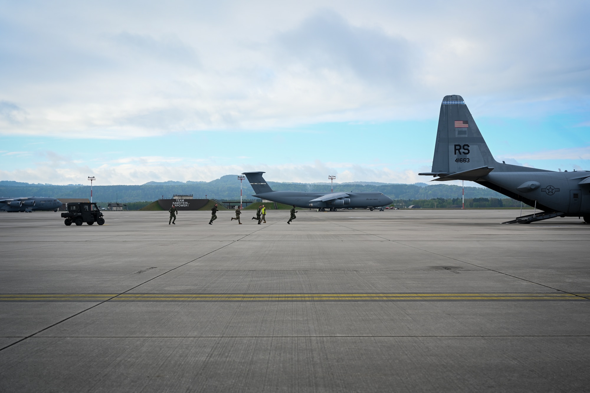 Members of the Royal Netherlands Air Force, 940th Squadron, Air Mobility Command, from Eindhoven Air Base, Netherlands, run towards a C-130J Super Hercules in the 521st Air Mobility Operations Wing Mobility Vanguard 2025 at Ramstein Air Base, Germany, May 24, 2025.