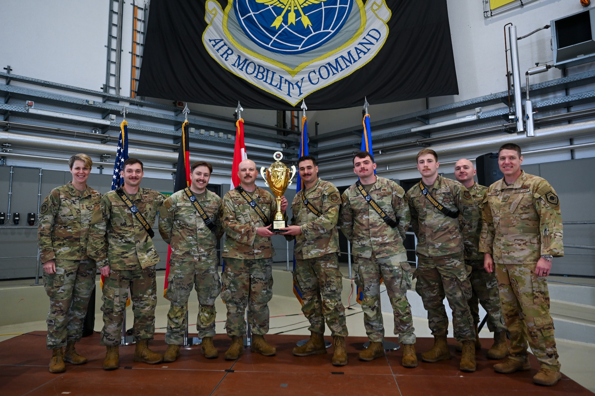 U.S. Air Force Lt. Gen. Rebecca Sonkiss, far left, Air Mobility Command deputy commander, and the 521st Air Mobility Operations Wing command team pose for a photo with members of the 305th Aircraft Maintenance Squadron from Joint Base McQuire-Dix-Lakehurst, New Jersey, who were coined the champions of the 521st AMOW’s Mobility Vanguard 2025, in Hangar 5 at Ramstein Air Base, Germany, April 25, 2025.