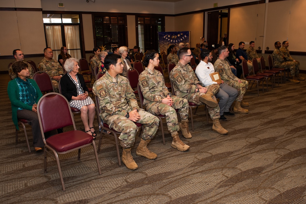 Volunteers and family sit in the audience for the annual event