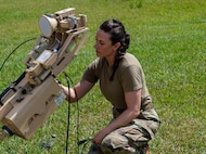 U.S. Air National Guard Technical Sgt. Kelsey Towle, a Radio Frequency Transmission Systems Technician with the 265th Combat Communications Squadon, prepares an antennae to establish communications on April 28th, 2025, at Aguadilla, Puerto Rico.