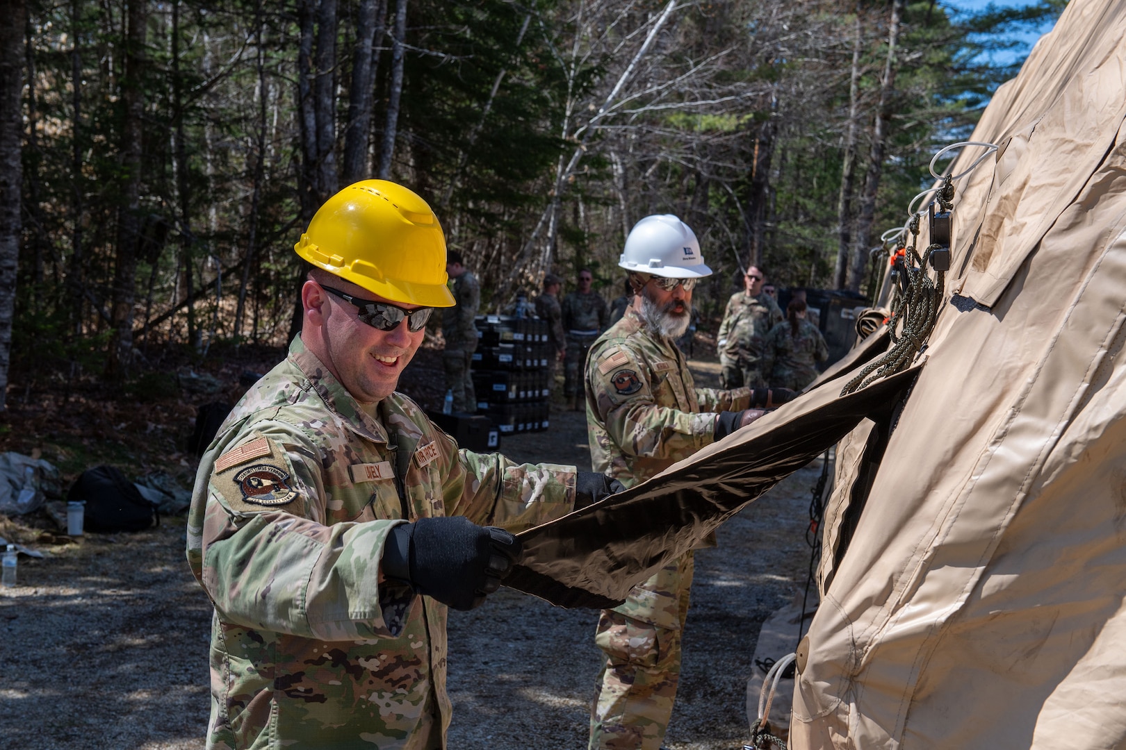 U.S. Air National Guard Senior Airman Edward Lovely, left, and Senior Airman Drupinderbir Khaira, both with the 265th Combat Communications Squadron, collaborate to prepare a communications tent during the 265th annual exercise April 25th, 2025 at Great Pond, Maine.
