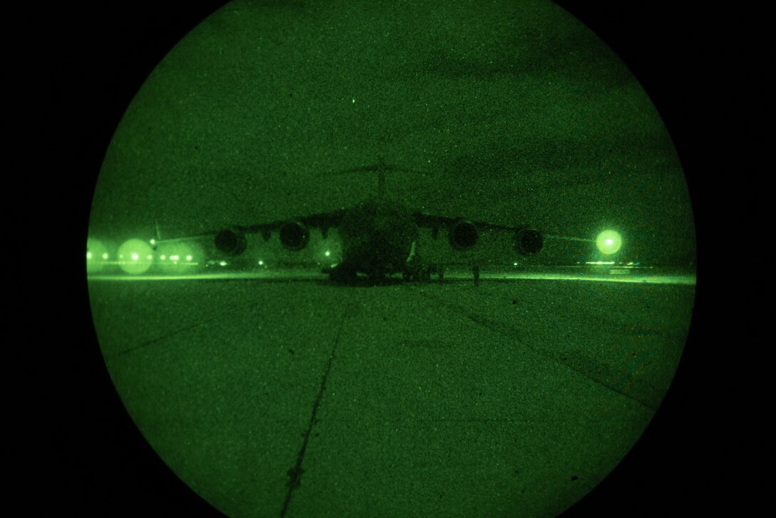 U.S. Air Force C-17 Globemaster III aircrew assigned to the 701st Airlift Squadron, 315th Airlift Wing, prepare to load an M142 High Mobility Artillery Rocket System during a night tactics exercise as part of Weapons and Tactics Instructor course 2-25 at Marine Corps Logistics Base Barstow, California, April 7, 2025. WTI is a seven-week training event hosted by Marine Aviation Weapons and Tactics Squadron One (MAWTS-1) which emphasizes operational integration of the six functions of Marine aviation in support of the Marine Air Ground Task Force, Joint and Coalition Forces. (U.S. Marine Corps photo by Pfc. Alexander Mantai)