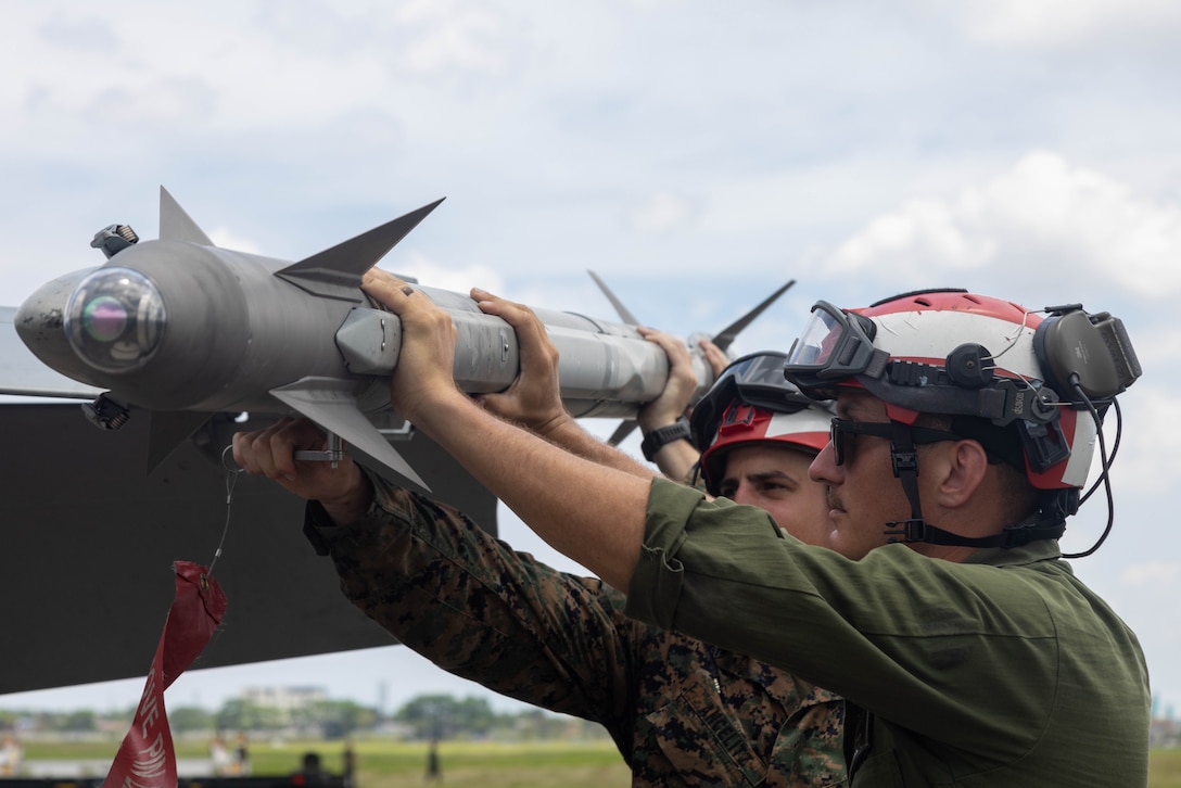 U.S. Marine Corps Sgt. Theodore Ancelitz and Sgt. Cameron Miley, both aircraft ordnance technicians with Marine Fighter Attack Squadron 323, Marine Aircraft Group 11, 3rd Marine U.S. Marine Corps Sgt. Theodore Ancelitz and Sgt. Cameron Miley, both aircraft ordnance technicians with Marine Fighter Attack Squadron (VMFA) 323, Marine Aircraft Group 11, 3rd Marine Aircraft Wing, load ordnance on to an F/A-18D Hornet assigned to VMFA-323, Marine Aircraft Group 11, 3rd MAW in support of Exercise Balikatan 25, at Clark Air Base, Philippines, May 5, 2025. Balikatan is a longstanding annual exercise between the U.S. and Philippine armed forces designed to strengthen the alliance, showcase the capable combined force, and demonstrate the commitment to regional security and stability. (U.S. Marine Corps photo by Lance Cpl. Erica S Padgett)