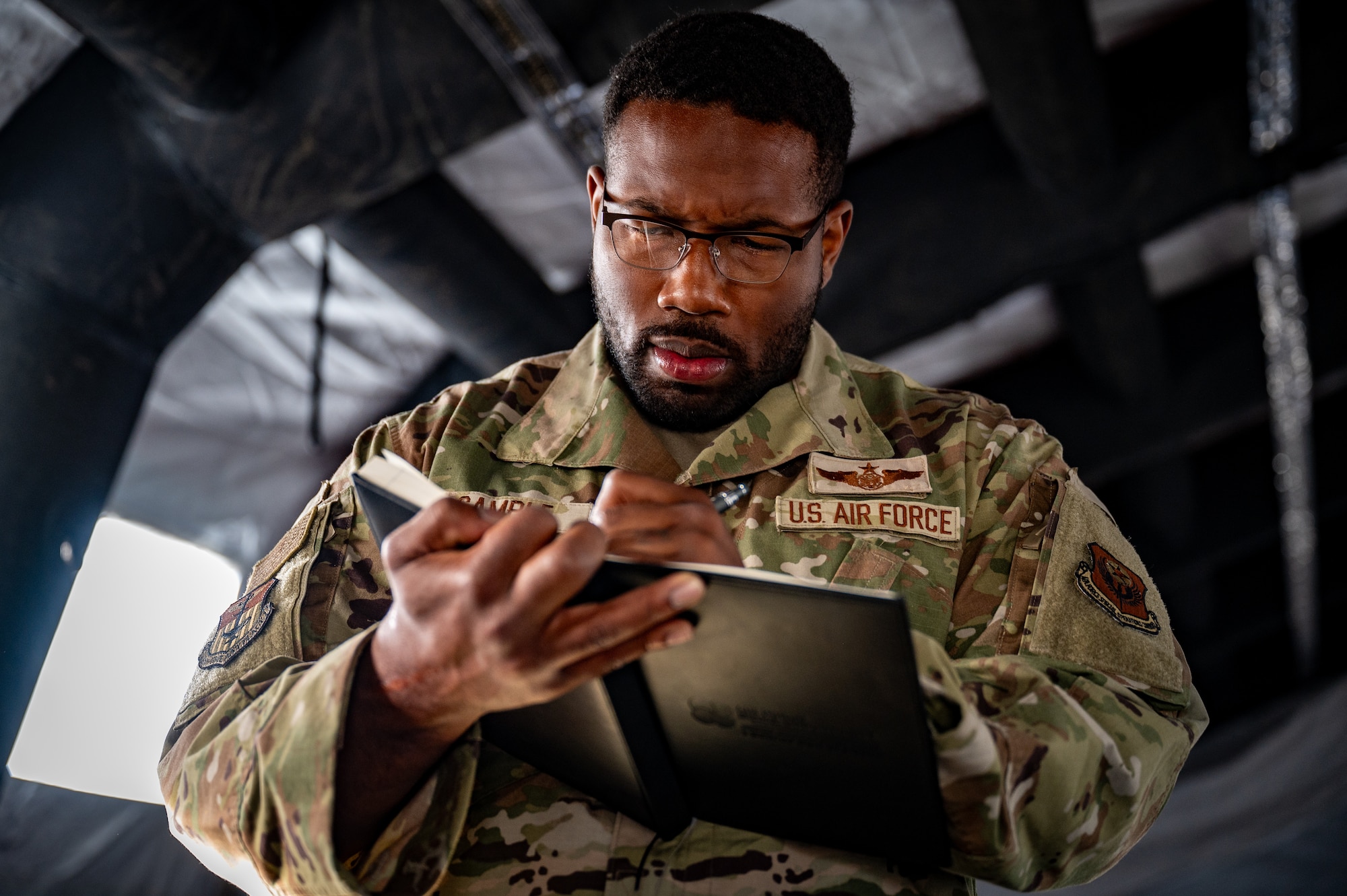 U.S. Air Force Master Sgt. Darius Gamble, a first sergeant assigned to the 1st Special Operations Wing from Hurlburt Field, Fla., takes notes at Camp Madbull during the first-ever Pacific Air Forces First Sergeant Readiness Summit at Joint Base Elmendorf-Richardson, Alaska, May 6. The summit brought more than 100 first sergeants from various major commands to put first sergeant responsibilities into action and improve their combat readiness. (U.S. Air Force photo by Airman 1st Class Hunter Hites)