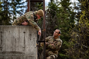 U.S. Air Force Master Sgt. Samuel Weaver (left), a first sergeant assigned to the 734 Air Mobility Squadron from Andersen Air Force Base, Guam, and Master Sgt. Isaac Schooler (right), a first sergeant assigned to the 18th Security Forces Squadron from Kadena Air Base, Japan, set up communications equipment at Camp Madbull during the first-ever Pacific Air Forces First Sergeant Readiness Summit on Joint Base Elmendorf-Richardson, Alaska, May 6, 20251. The summit brought more than 100 first sergeants from various major commands to put first sergeant responsibilities into action and improve their combat readiness. (U.S. Air Force photo by Airman 1st Class Hunter Hites)
